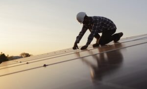 Un ingénieur vérifiant l'installation de panneaux solaires sur une toiture.