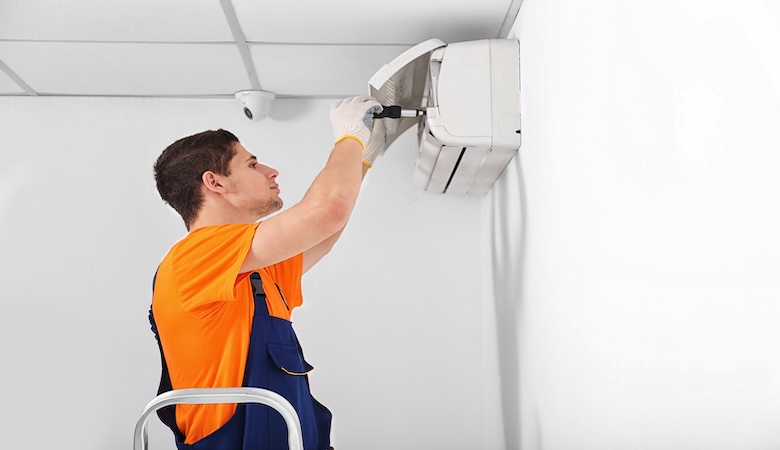 Nous voyons un technicien installant une climatisation.