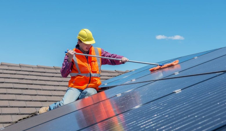 un homme qui nettoie des panneaux solaires