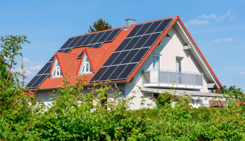 maison avec un toit en tuiles et des panneaux solaires