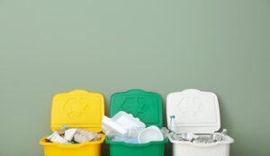 Trois poubelles différentes. Une verte, une jaune et une blanche.