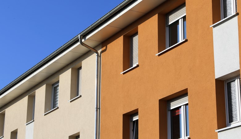 maisons mitoyennes avec des façades colorées dans les tons jaunes, oranges et beiges.