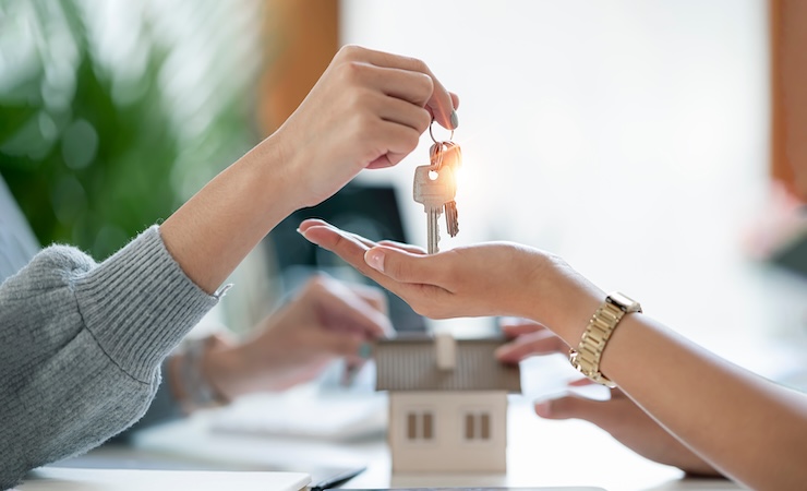 Réception de clé avec une maison factice en arrière-plan.